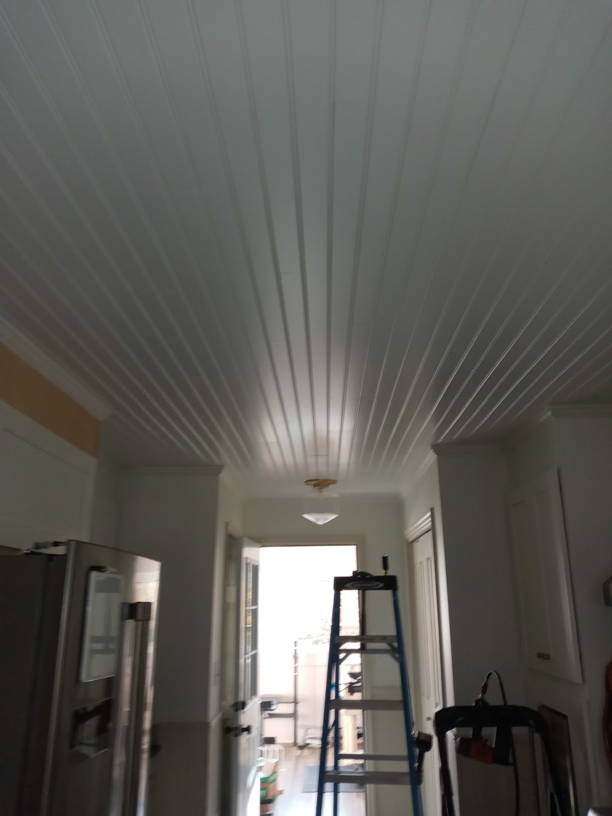 White shiplap ceiling installed in a kitchen and hallway