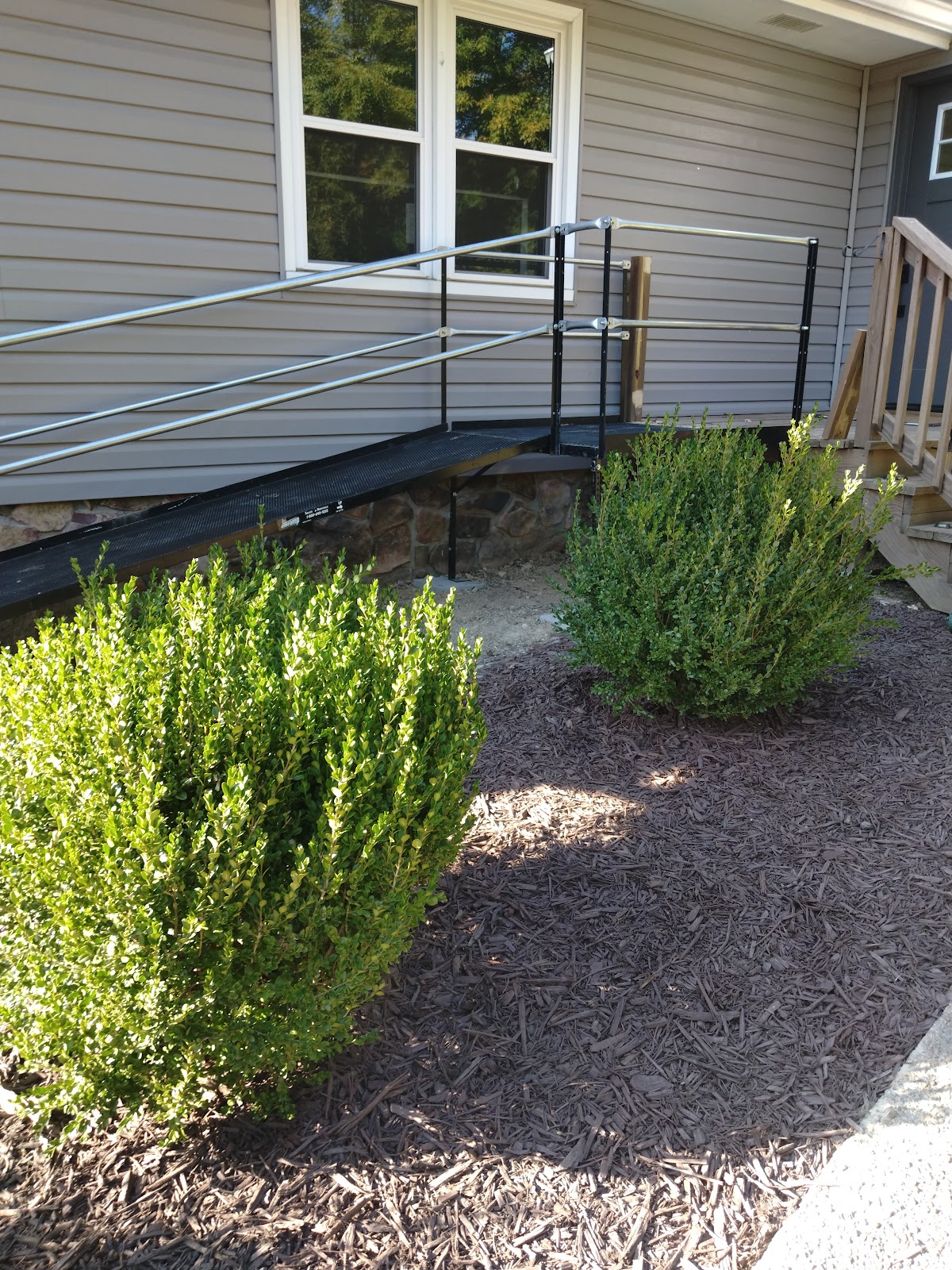 Wheelchair access ramp with metal railings leading to a front porch
